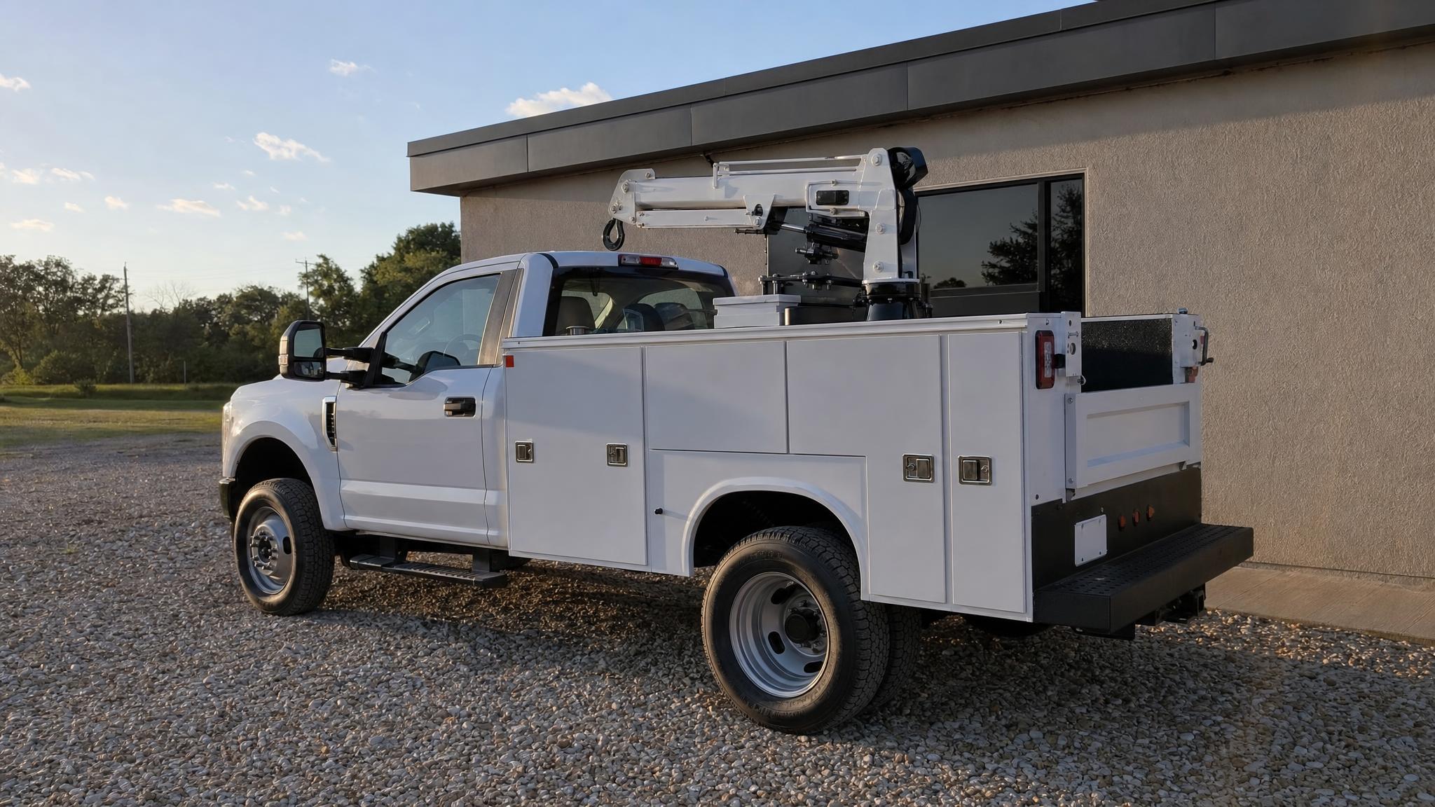 White service body with a compact crane behind the cab