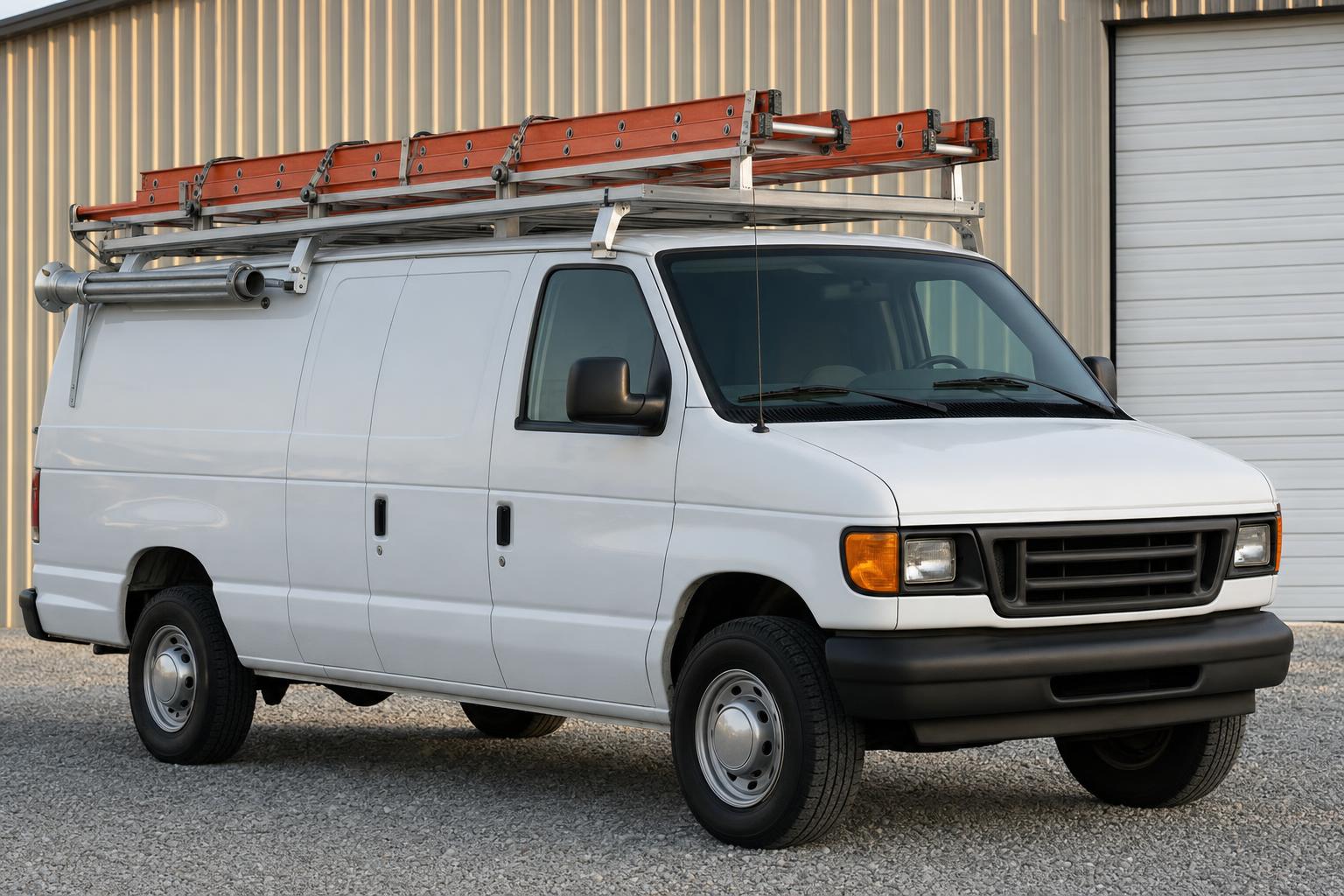 White cargo van with an aluminum ladder rack and orange ladders